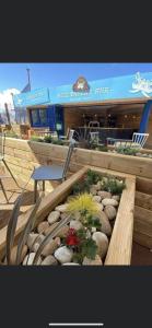 a bench with a chair and some plants and a building at Marine Holiday Park D&S rental B in Rhyl