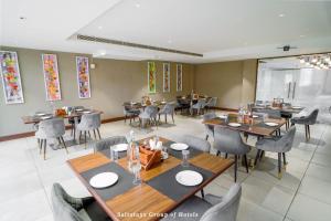 a dining room with tables and chairs in a restaurant at Saltstayz Le Icon- Cyber Hub and DLF Downtown -8KM from IGI Airport in Gurgaon