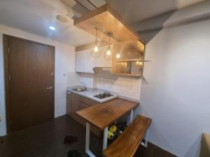 a small kitchen with a wooden table and a sink at SIGNATURE PARK GRANDE MT.Haryono in Jakarta