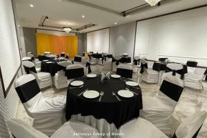sala konferencyjna ze stołem i białymi krzesłami w obiekcie Saltstayz Le Icon- Cyber Hub w mieście Gurgaon