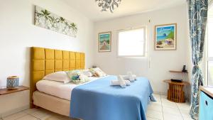 A bed or beds in a room at Atlantis, Magnifique T2, vue mer, proche plage, Anse Mitan