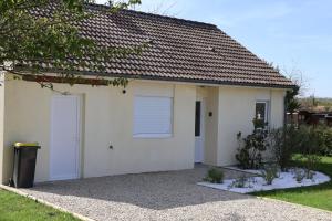 een klein wit huis met een garage bij Les gîtes coquins in Amilly