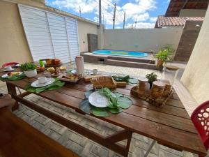 un tavolo in legno con cibo in cima a un patio di CASA COM PISCINA GARANHUNS a Garanhuns