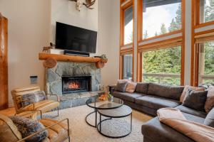 ウィスラーにあるLuxury Mountain Retreat with PRIVATE Hot Tub by Harmony Whistlerのソファと暖炉のあるリビングルーム
