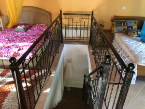 1 dormitorio con 1 cama y una escalera con un gato en el suelo en Villa Melpo en Likodhrómion