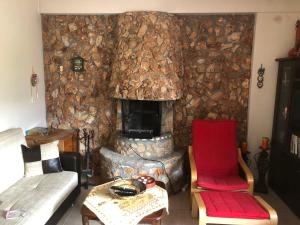 sala de estar con pared de piedra y chimenea en Villa Melpo en Likodhrómion