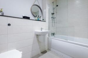 a white bathroom with a sink and a bath tub at Victoria Mill by Staycay in Wigan
