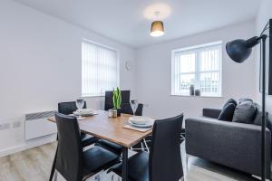 a dining room and living room with a table and chairs at Victoria Mill by Staycay in Wigan