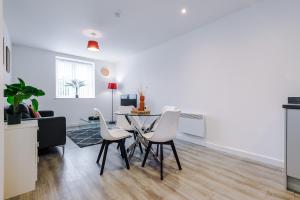 a kitchen and living room with a table and chairs at Victoria Mill by Staycay in Wigan