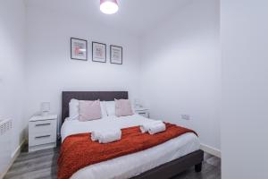a white bedroom with a bed with a red blanket at Victoria Mill by Staycay in Wigan