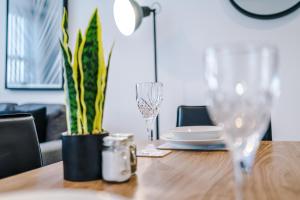 a wooden table with glasses and a plate on it at Victoria Mill by Staycay in Wigan