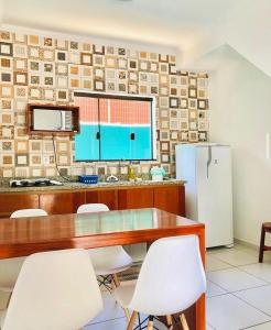 a kitchen with a table and chairs and a refrigerator at Apartamentos Recanto da Barra in Ubatuba