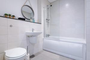 a bathroom with a toilet and a tub and a sink at Victoria Mill by Staycay in Wigan