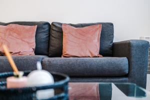 a blue couch with two orange pillows on it at Victoria Mill by Staycay in Wigan