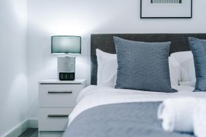 a bedroom with a bed and a night stand with a lamp at Victoria Mill by Staycay in Wigan