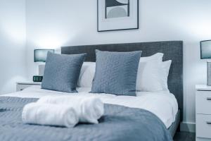 a bed with white sheets and pillows in a bedroom at Victoria Mill by Staycay in Wigan