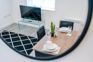 a dining room table with chairs and a mirror at Victoria Mill by Staycay in Wigan