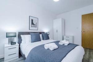 um quarto com uma cama grande e toalhas em Victoria Mill by Staycay em Wigan