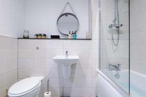 uma casa de banho com um WC, um lavatório e um espelho. em Victoria Mill by Staycay em Wigan