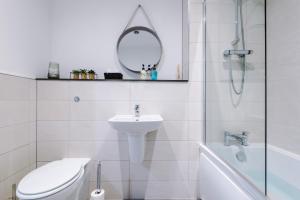 a bathroom with a toilet and a sink and a mirror at Victoria Mill by Staycay in Wigan