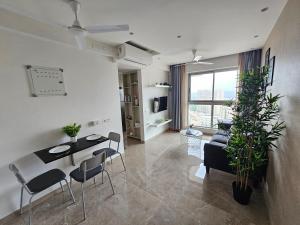 a living room with a table and chairs and a couch at Lite Stays in Mumbai