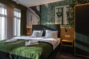 ein Hotelzimmer mit einem Bett, auf dem Handtücher liegen in der Unterkunft Oliva Hotel in Veszprém