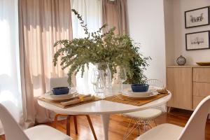 una mesa de comedor blanca con un jarrón de flores en Cuencaloft Luxurious, en Cuenca