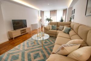 Una sala de estar con un sofá y un televisor. en Cuencaloft Luxurious, en Cuenca