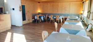 Garni Alba Bed & Breakfast في أورتيساي: مطعم فيه طاولات وكراسي في الغرفة