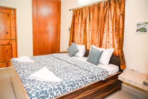 1 dormitorio con cama grande y cortina en Nirmalesh Bhawan Family Villa en Mussoorie