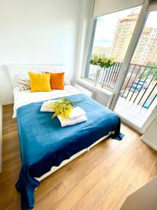 1 dormitorio con 1 cama con sábanas azules y almohadas amarillas en Люкс апартаменти в затишному ЖК бізнес класу, en Kiev