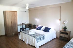 - une chambre avec un lit, un bureau et une chaise dans l'établissement VOA Hotel Rezende, à Lambari
