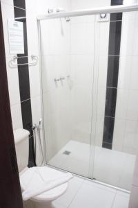 La salle de bains est pourvue d'une douche et de toilettes. dans l'établissement VOA Hotel Rezende, à Lambari