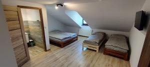 a small room with two beds and a mirror at Pokoje u Juroszka in Istebna