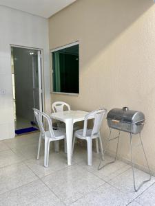 un tavolo e sedie bianchi e una griglia in camera di Casa do Lamarques a Piranhas