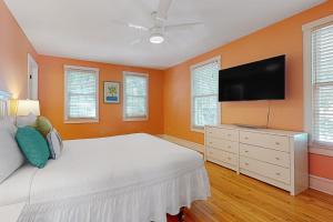 a bedroom with a bed and a flat screen tv at Baya House in Key West