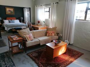uma sala de estar com um sofá e uma cama em Pied Cow Cottage em Hilton