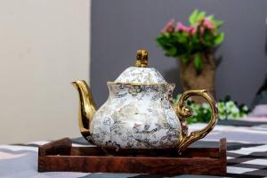 a white and gold tea pot on a table at Atithi Stay By Kasa Lusso - Luxury 2 BHK In Faridabad in Faridabad