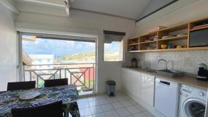 A kitchen or kitchenette at Ti Caraïbes, appartement T3 atypique, vue mer, piscine et proche plage
