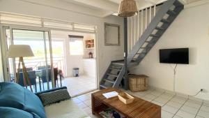 A television and/or entertainment centre at Ti Caraïbes, appartement T3 atypique, vue mer, piscine et proche plage
