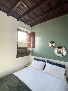 a bedroom with a bed with white sheets and a window at DomusLu' - Casa di charme nel cuore di Roma in Rome