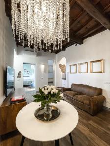 a living room with a table and a chandelier at DomusLu' - Casa di charme nel cuore di Roma in Rome