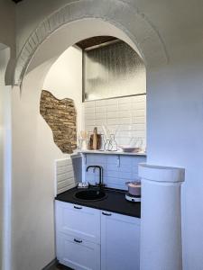 a kitchen with a sink and an archway at DomusLu' - Casa di charme nel cuore di Roma in Rome