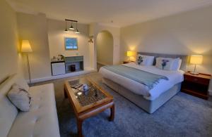 een hotelkamer met een groot bed en een bank bij The Four Seasons Hotel in Saint Fillans