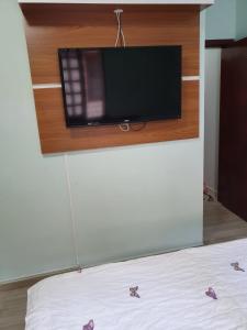 フロリアノポリスにあるPOUSADA JUREREのベッド1台、壁に薄型テレビが備わる客室です。