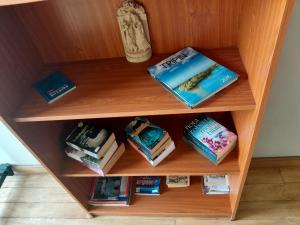 a wooden book shelf with books on it at Villa Arunalu Kandy in Kandy