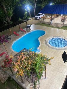 una piscina en un patio con mesa y sillas en AKUAIPPA HOSTAL RESTAURANT, en Santa Marta