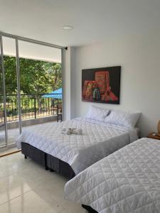 a bedroom with a bed and a large window at AKUAIPPA HOSTAL RESTAURANT in Santa Marta