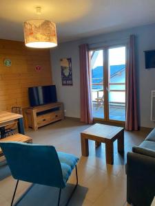 una sala de estar con un sofá y una mesa en T2 avec vue à 30m des télécabines, en Font-Romeu-Odeillo-Via