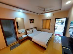 ein Schlafzimmer mit einem großen Bett und einem TV in der Unterkunft Gir Jungle Lodge in Sasan Gir